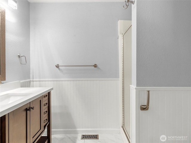 3929 Westpark Ct NW, Olympia, WA 98502 - full bathroom with wainscoting, vanity, a stall shower, and marble finish floors