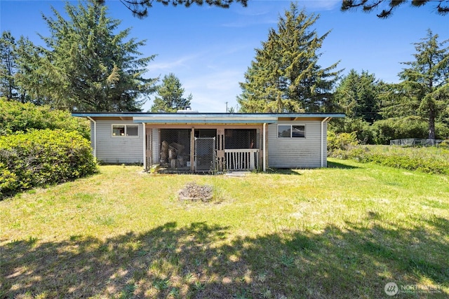 324 Mizzen Ave NW, Ocean Shores, WA 98569 - rear view of property featuring an outdoor structure and a lawn