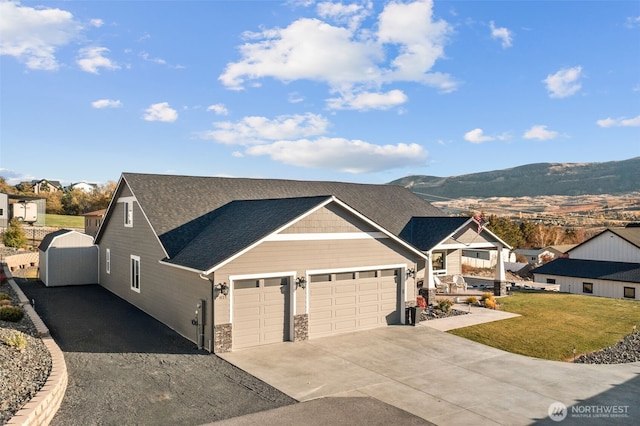 821 S Mary Ave, East Wenatchee, WA 98802 - view of front of house with an attached garage, concrete driveway, a front lawn, roof with shingles, and a mountain view
