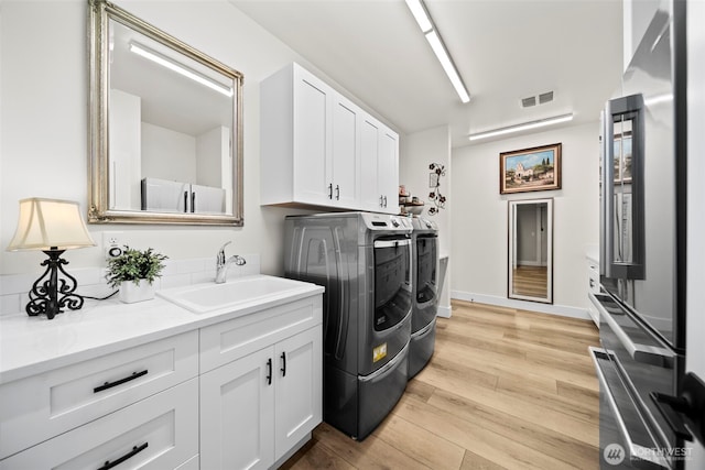 821 S Mary Ave, East Wenatchee, WA 98802 - laundry area with washer and clothes dryer, cabinet space, and light wood-style floors