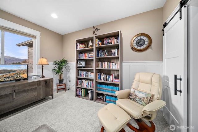 821 S Mary Ave, East Wenatchee, WA 98802 - living area featuring a barn door, carpet, wainscoting, recessed lighting, and a decorative wall