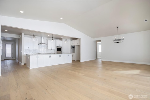 11413 Interlaaken Dr SW, Lakewood, WA 98498 - kitchen with wall chimney range hood, vaulted ceiling, a chandelier, white cabinets, and light wood-style floors