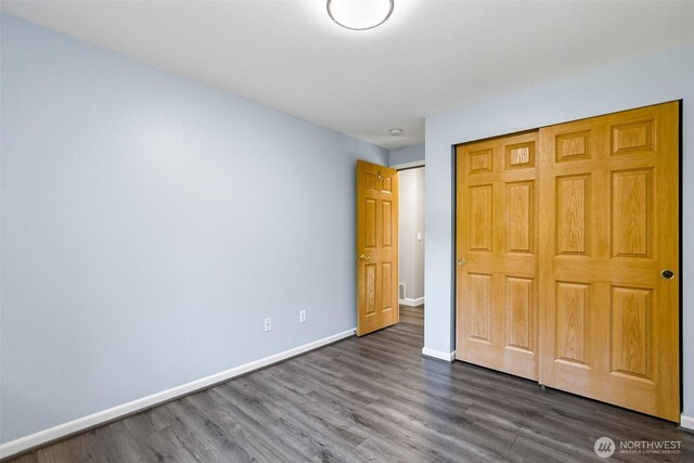 3218 127th Ave NE, Lake Stevens, WA 98258 - unfurnished bedroom featuring dark wood-type flooring and a closet