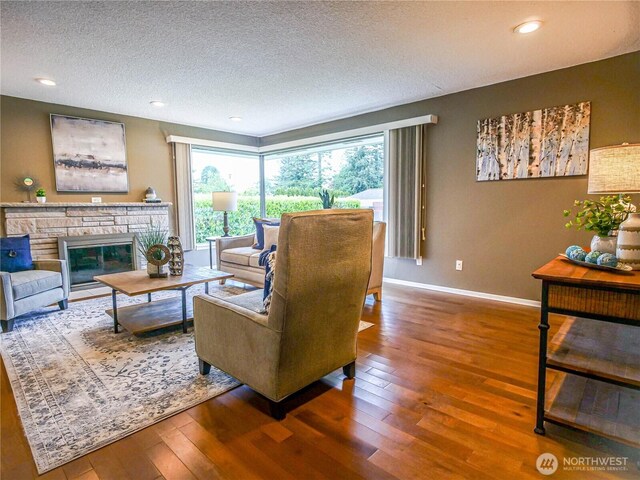 1709 NW 99th St, Seattle, WA 98117 - living area with hardwood / wood-style floors, a textured ceiling, baseboards, a fireplace, and recessed lighting