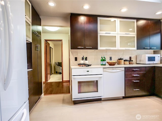 1709 NW 99th St, Seattle, WA 98117 - kitchen featuring white appliances, light countertops, glass insert cabinets, tasteful backsplash, and light wood-type flooring