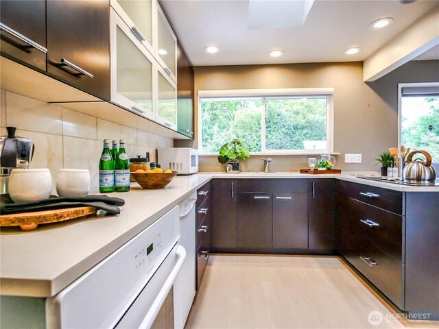1709 NW 99th St, Seattle, WA 98117 - kitchen with white microwave, dark brown cabinets, light countertops, a sink, and tasteful backsplash