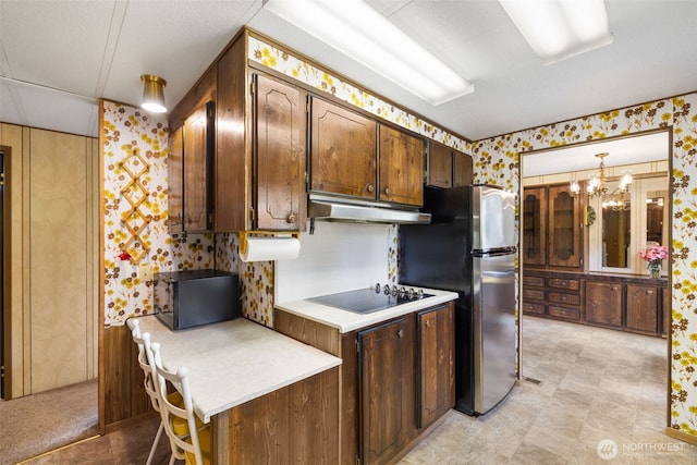 1171 E Trails End Dr, Belfair, WA 98528 - kitchen featuring wallpapered walls, under cabinet range hood, black appliances, and light countertops