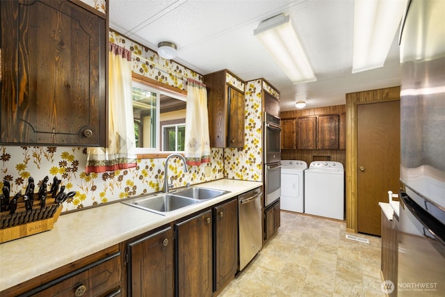 1171 E Trails End Dr, Belfair, WA 98528 - kitchen with washing machine and dryer, appliances with stainless steel finishes, light countertops, wallpapered walls, and dark brown cabinetry