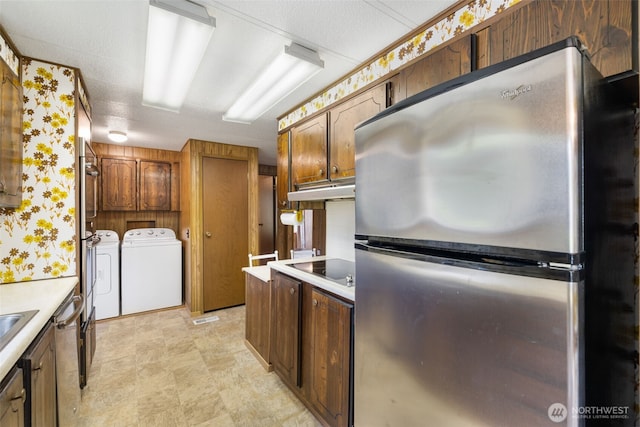 1171 E Trails End Dr, Belfair, WA 98528 - kitchen featuring appliances with stainless steel finishes, separate washer and dryer, light countertops, brown cabinets, and under cabinet range hood