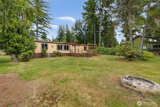 1171 E Trails End Dr, Belfair, WA 98528 - view of grassy yard featuring a fire pit and a wooden deck
