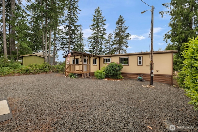 1171 E Trails End Dr, Belfair, WA 98528 - manufactured / mobile home featuring a wooden deck, a shed, and gravel driveway
