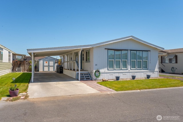 2240 W Broadway Ave Unit 25, Moses Lake, WA 98837 - manufactured / mobile home featuring central air condition unit, concrete driveway, and a carport