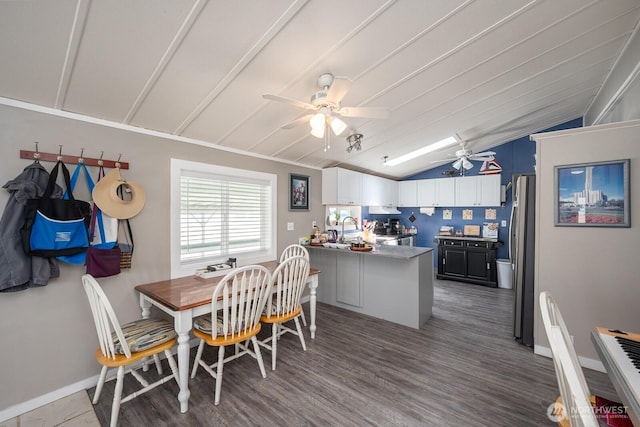 2240 W Broadway Ave Unit 25, Moses Lake, WA 98837 - dining room featuring vaulted ceiling, a ceiling fan, wood finished floors, and baseboards