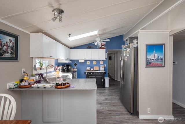 2240 W Broadway Ave Unit 25, Moses Lake, WA 98837 - kitchen featuring freestanding refrigerator, a sink, wood finished floors, a peninsula, and lofted ceiling