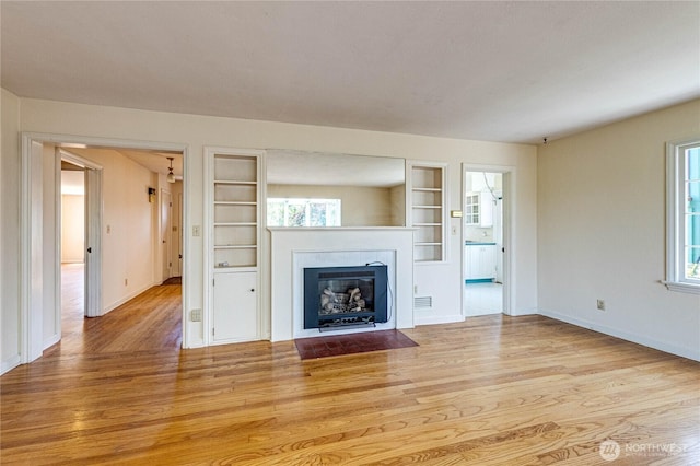 1415 E 2nd St, Port Angeles, WA 98362 - unfurnished living room featuring wood finished floors, built in features, and a fireplace with flush hearth