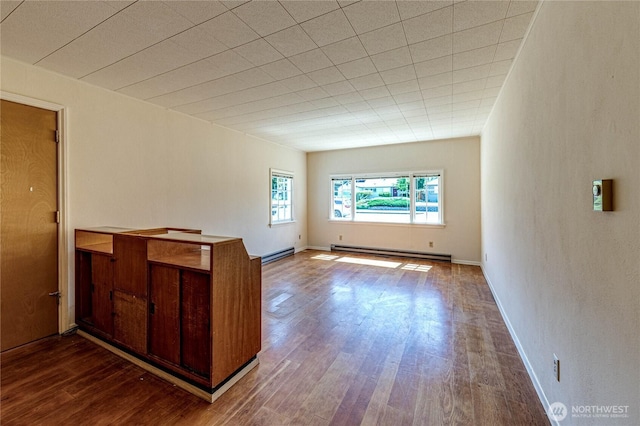 1415 E 2nd St, Port Angeles, WA 98362 - unfurnished room featuring a baseboard heating unit and dark wood-style flooring