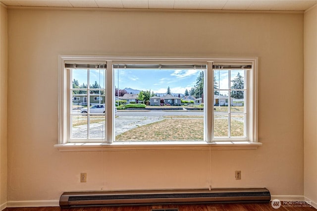 1415 E 2nd St, Port Angeles, WA 98362 - empty room with healthy amount of natural light, a baseboard heating unit, a residential view, and wood finished floors