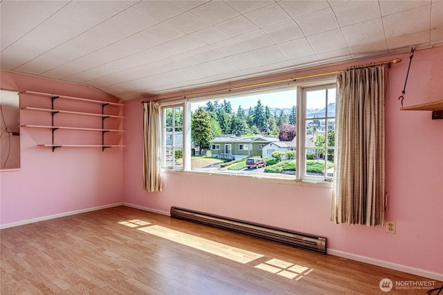 1415 E 2nd St, Port Angeles, WA 98362 - empty room with baseboard heating, wood finished floors, and vaulted ceiling