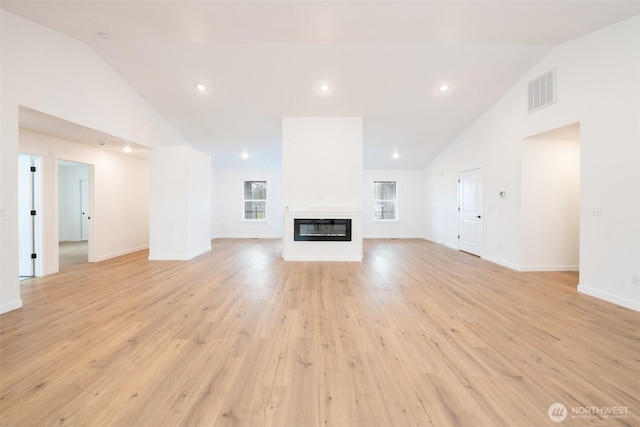 24 Hurd Rd, Elma, WA 98541 - unfurnished living room featuring high vaulted ceiling, light wood-style floors, a glass covered fireplace, and recessed lighting