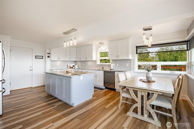 2483 Hilltop Rd, Ferndale, WA 98248 - kitchen featuring stainless steel dishwasher, light wood-type flooring, tasteful backsplash, and white cabinetry