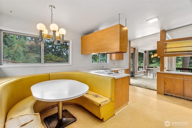 2219 Yelm Hwy SE, Olympia, WA 98501 - kitchen with a chandelier, light countertops, brown cabinets, decorative light fixtures, and a peninsula