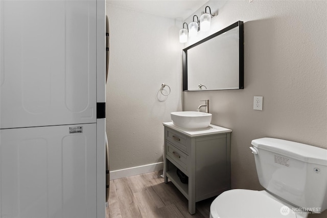 135 F St SE, Ephrata, WA 98823 - bathroom with stacked washer / dryer, wood finished floors, and vanity
