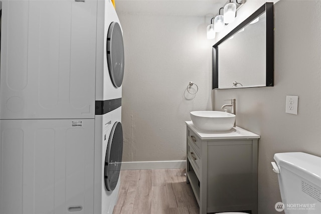 135 F St SE, Ephrata, WA 98823 - laundry area with stacked washer and clothes dryer and light wood finished floors