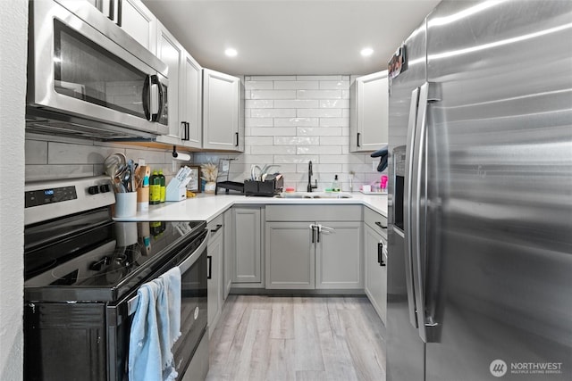 135 F St SE, Ephrata, WA 98823 - kitchen with stainless steel appliances, tasteful backsplash, light countertops, light wood-type flooring, and recessed lighting