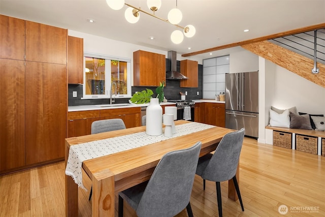 3659 Whitman Ave N, Seattle, WA 98103 - kitchen featuring appliances with stainless steel finishes, wall chimney exhaust hood, decorative backsplash, brown cabinetry, and recessed lighting
