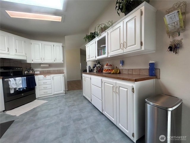 72 Misty Glen Ln, Sequim, WA 98382 - kitchen featuring black electric range, white cabinets, backsplash, and light flooring
