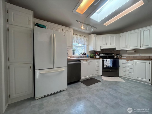 72 Misty Glen Ln, Sequim, WA 98382 - kitchen with freestanding refrigerator, range with electric stovetop, rail lighting, a skylight, and white cabinets