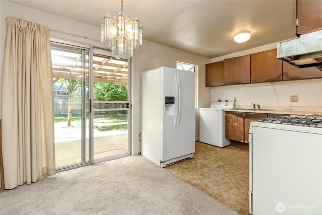 26622 190th Ave SE, Covington, WA 98042 - kitchen with washer / dryer, white appliances, exhaust hood, and plenty of natural light