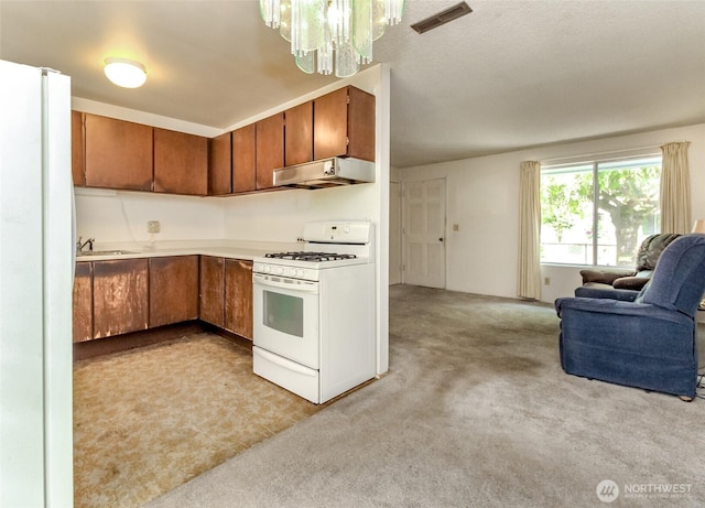 26622 190th Ave SE, Covington, WA 98042 - kitchen with white appliances, under cabinet range hood, open floor plan, brown cabinetry, and a chandelier