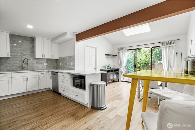 8739 17th Ave NW, Seattle, WA 98117 - kitchen with black microwave, white cabinetry, dishwasher, tasteful backsplash, and light wood-type flooring