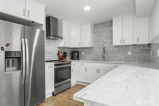 8739 17th Ave NW, Seattle, WA 98117 - kitchen with stainless steel appliances, wall chimney exhaust hood, decorative backsplash, white cabinetry, and light wood-type flooring