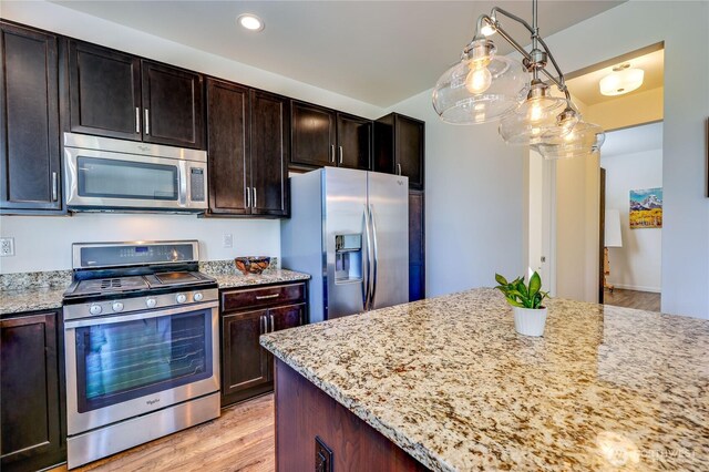 21598 NW Monterey Loop, Poulsbo, WA 98370 - kitchen featuring stainless steel appliances, light stone counters, recessed lighting, and light wood finished floors