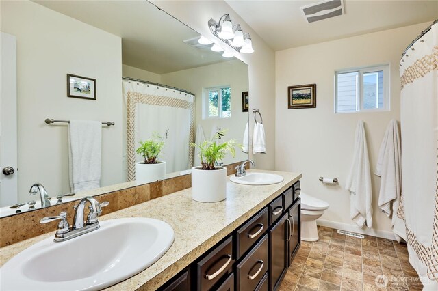 21598 NW Monterey Loop, Poulsbo, WA 98370 - bathroom featuring double vanity, stone finish floors, and a shower with curtain
