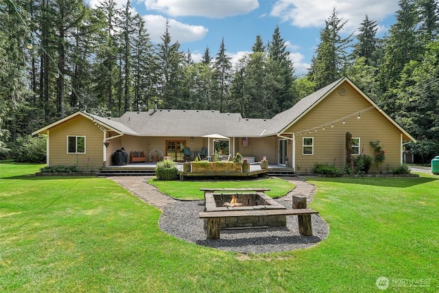 6611 Menzel Lake Rd, Granite Falls, WA 98252 - back of property featuring an outdoor fire pit, a wooden deck, and a lawn