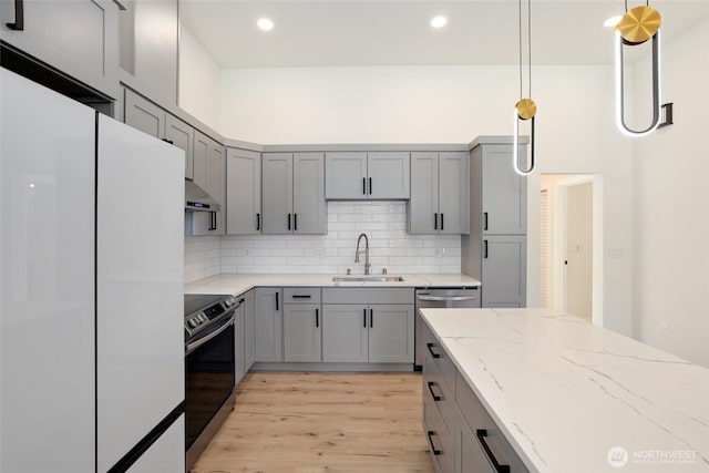 3124 Oas Dr W, University Place, WA 98466 - kitchen featuring stainless steel appliances, gray cabinets, under cabinet range hood, light wood-style floors, and light stone countertops