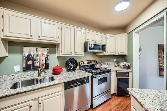 7930SE 34th St Unit 209, Mercer Island, WA 98040 - kitchen featuring stainless steel appliances, white cabinetry, light wood-style flooring, and light stone counters