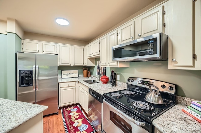 7930SE 34th St Unit 209, Mercer Island, WA 98040 - kitchen featuring stainless steel appliances, light wood finished floors, light stone countertops, and white cabinetry