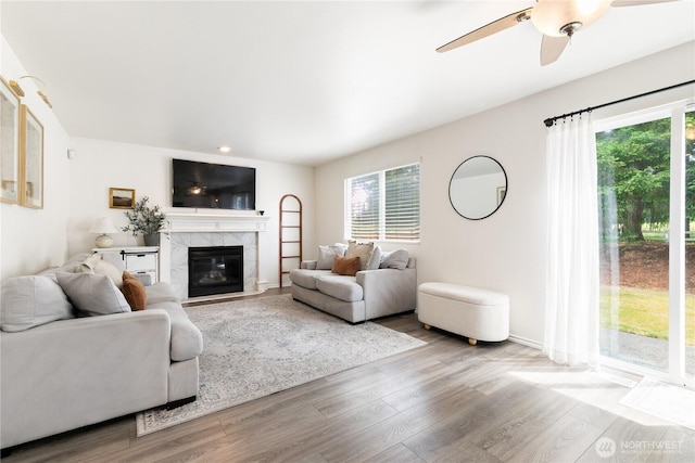 21323 47th Ave E, Spanaway, WA 98387 - living room with healthy amount of natural light, wood finished floors, a ceiling fan, a high end fireplace, and recessed lighting