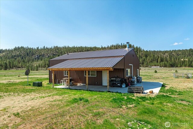 40359 Barbara Ln N, Davenport, WA 99122 - back of house with a view of trees, a lawn, metal roof, and board and batten siding