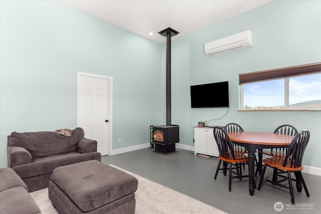 40359 Barbara Ln N, Davenport, WA 99122 - living area featuring a wood stove, an AC wall unit, baseboards, finished concrete flooring, and recessed lighting