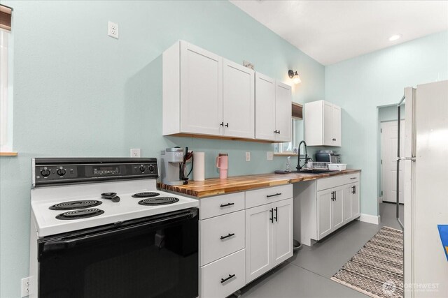 40359 Barbara Ln N, Davenport, WA 99122 - kitchen with range with electric stovetop, wooden counters, freestanding refrigerator, and white cabinets