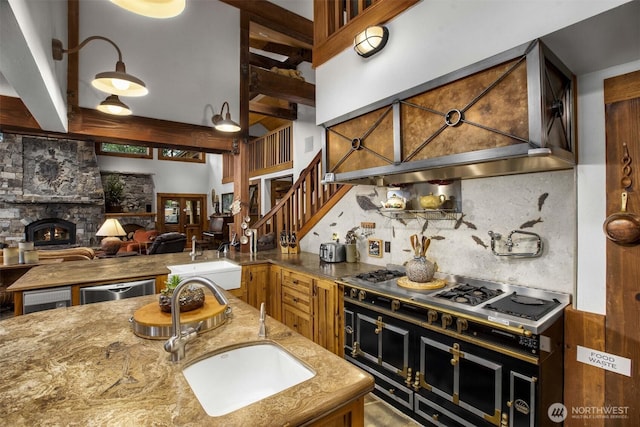 6286 Five Mile Rd, The Dalles, OR 98058 - kitchen with custom range hood, a stone fireplace, appliances with stainless steel finishes, open floor plan, and light stone countertops