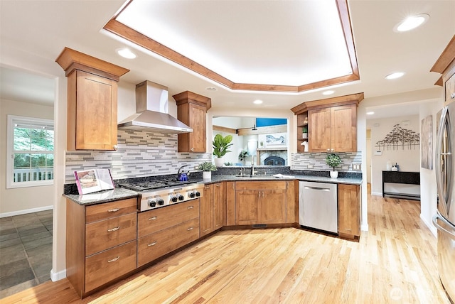 8495 Landing Ln SE, Port Orchard, WA 98367 - kitchen featuring stainless steel appliances, wall chimney range hood, a tray ceiling, backsplash, and open shelves
