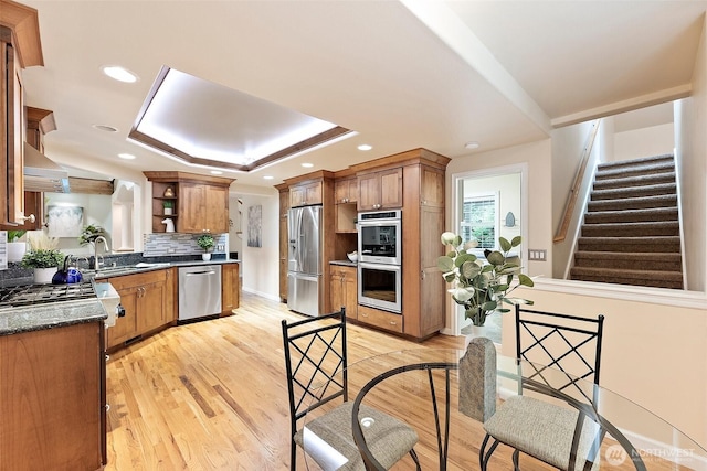 8495 Landing Ln SE, Port Orchard, WA 98367 - kitchen with appliances with stainless steel finishes, open shelves, a tray ceiling, backsplash, and light wood-style floors