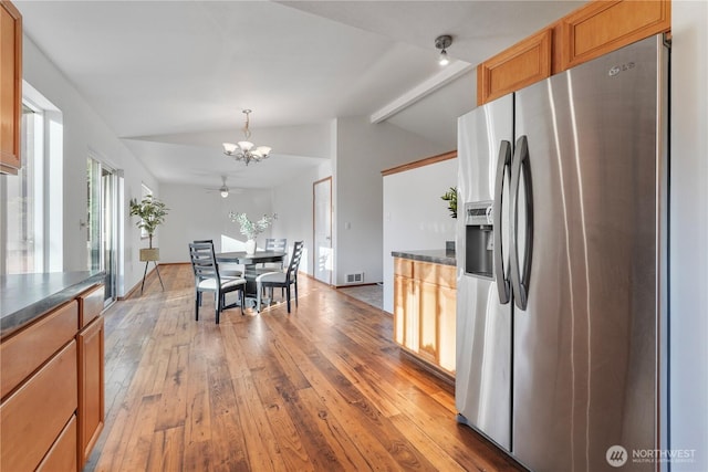 1910 192nd Avenue Ct SW, Lakebay, WA 98349 - kitchen with stainless steel fridge with ice dispenser, a chandelier, light wood-style floors, dark countertops, and brown cabinetry