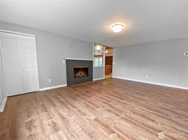 15518SE 304th Pl, Kent, WA 98042 - unfurnished living room with wood finished floors and a warm lit fireplace